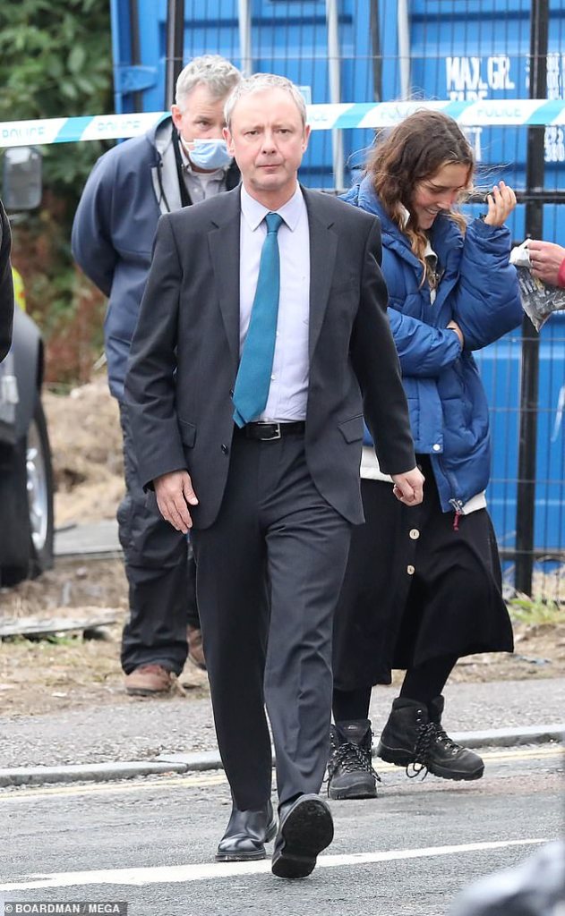 Suited and booted: John, 51, was spotted looking dapper in a charcoal suit, adding a splash of colour to his get-up with a cerulean blue tie. Photo: Boardman/Mega